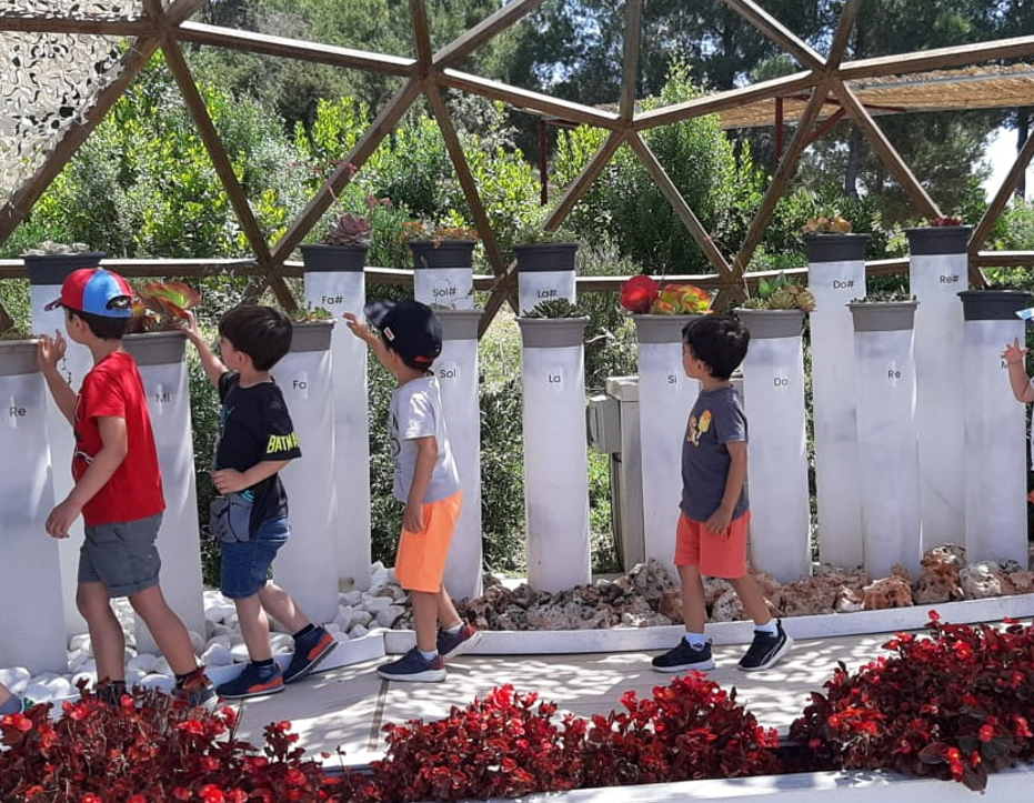 Niños tocando las plantas del piano vegetal de BiBo Park